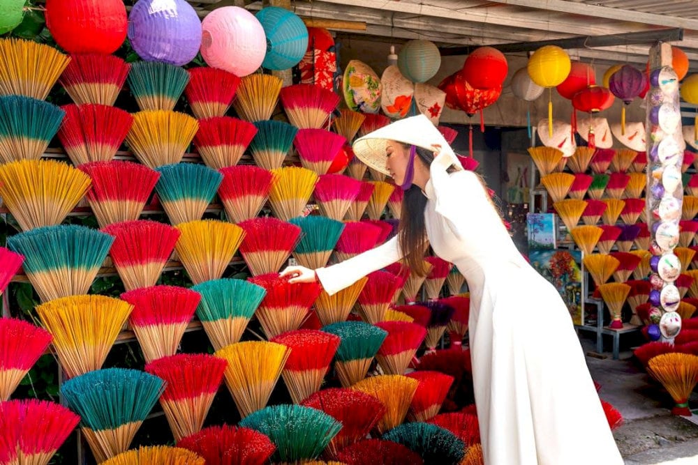 A vivid display of rainbow-colored incense sticks and traditional lanterns welcoming visitors to a workshop at Thuy Xuan Village 